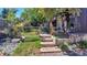 Picturesque backyard featuring lush landscaping, wooden steps, a charming patio, and a fenced garden area at 3650 Chimayo Rd, Littleton, CO 80123