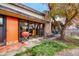 Charming backyard featuring a stone fireplace, orange door, grill, and outdoor dining with lovely greenery at 3650 Chimayo Rd, Littleton, CO 80123