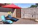 Charming backyard patio featuring lounge chairs, red umbrella, decorative lighting, and pea gravel at 3650 Chimayo Rd, Littleton, CO 80123