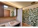 A bathroom featuring vibrant green tiles, a vintage vanity, and a bathtub with shower at 3650 Chimayo Rd, Littleton, CO 80123