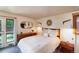 Cozy bedroom with neutral tones, wood furniture, decorative wall mirror, and a full-size bed at 3650 Chimayo Rd, Littleton, CO 80123