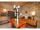 Retro dining area with wood table, stone wall, wood ceiling, and sleek retro fixtures at 3650 Chimayo Rd, Littleton, CO 80123