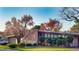 A contemporary home displaying a stone facade, clean lines, and mature trees at 3650 Chimayo Rd, Littleton, CO 80123