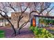 A charming home with unique architectural details, an orange front door, and mature landscaping at 3650 Chimayo Rd, Littleton, CO 80123