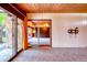 Spacious living room with wood paneling and sliding glass doors to the outside patio at 3650 Chimayo Rd, Littleton, CO 80123