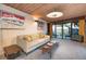 Cozy living room featuring retro style decor, wood paneled ceilings, and sliding glass doors at 3650 Chimayo Rd, Littleton, CO 80123