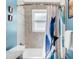 Bathroom featuring shower-tub combo with a decorative curtain and window at 1185 Glencoe St, Denver, CO 80220