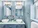 Bathroom with double vanity, modern fixtures, and blue accents at 1185 Glencoe St, Denver, CO 80220