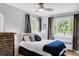 Bedroom features natural light, a ceiling fan, and a queen-sized bed with gray and blue accents at 1185 Glencoe St, Denver, CO 80220
