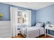 Sunny bedroom featuring hardwood floors and blue walls at 1185 Glencoe St, Denver, CO 80220
