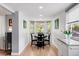 A bright dining room with a table set for four, featuring a large window with a view of the outdoors at 1185 Glencoe St, Denver, CO 80220