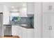 Kitchen with stainless steel appliances, white cabinetry, and corner sink at 1185 Glencoe St, Denver, CO 80220