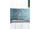 Close up of kitchen sink featuring sleek faucet and stylish backsplash at 1185 Glencoe St, Denver, CO 80220