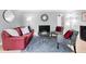 A comfortable living room featuring hardwood floors, a modern fireplace, and stylish furniture with red accents at 1185 Glencoe St, Denver, CO 80220