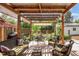 Charming outdoor patio with a corrugated roof, comfortable seating, and lush landscaping at 1185 Glencoe St, Denver, CO 80220