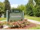 Mayfair Park sign surrounded by lush greenery and vibrant rose bushes in a serene neighborhood setting at 1185 Glencoe St, Denver, CO 80220
