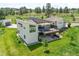 Aerial view of a modern home featuring a spacious deck, lush backyard, mature trees, and a detached garage at 10205 Inspiration Dr, Parker, CO 80138