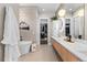 Spa bathroom features walk-in closet, soaking tub, modern vanity and stylish light fixtures at 10205 Inspiration Dr, Parker, CO 80138