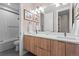 Modern bathroom with double vanity, large mirror, and shower/tub combo at 10205 Inspiration Dr, Parker, CO 80138