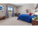 Spacious bedroom with sitting area, large window, and blue bedding at 10205 Inspiration Dr, Parker, CO 80138