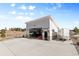 Detached garage with a light gray exterior, stone accents, and a large concrete driveway at 10205 Inspiration Dr, Parker, CO 80138