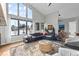 Bright living room featuring expansive windows, plush seating, stylish decor, and ample natural light, perfect for relaxation at 10205 Inspiration Dr, Parker, CO 80138