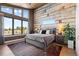 Bright main bedroom featuring large windows offering beautiful views and rustic reclaimed wood wall at 10205 Inspiration Dr, Parker, CO 80138