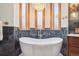 Bathroom featuring a freestanding tub with a towel, intricate tiles, and a modern chandelier at 1022 N Pearl St # 101, Denver, CO 80203