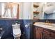 Bathroom with blue subway tile, a unique mirror, and wood cabinets at 1022 N Pearl St # 101, Denver, CO 80203