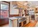 A spacious kitchen with a large gas cooktop on the island, wood floors, and stainless steel appliances at 1022 N Pearl St # 101, Denver, CO 80203