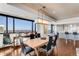 Modern dining room features hardwood floors, city views from the large windows, and a unique hanging light fixture at 1133 14Th St # 3320, Denver, CO 80202