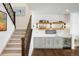 Elegant bar area with gray cabinetry, open shelving, wine fridge, and stair access at 2966 Casalon Cir, Superior, CO 80027