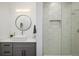 Contemporary bathroom with a round mirror, white countertop, and a tiled walk-in shower at 2966 Casalon Cir, Superior, CO 80027