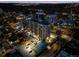An illuminated aerial view reveals the building, parking, tennis court, and surrounding neighborhood at night at 800 N Pearl St # 1203, Denver, CO 80203