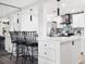 Open-concept kitchen boasts white cabinets, quartz countertops, stainless appliances, and bar seating at 800 N Pearl St # 1203, Denver, CO 80203