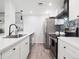 Modern kitchen features white cabinets, quartz countertops, stainless steel appliances, and stylish tile backsplash at 800 N Pearl St # 1203, Denver, CO 80203