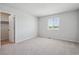 Bright bedroom with gray carpet, light gray walls, a window with blinds, and closet space at 10065 Quari Ct, Commerce City, CO 80022