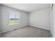 This bedroom features gray carpet, light gray walls, a window, and a closet, offering a simple and clean design at 10065 Quari Ct, Commerce City, CO 80022