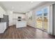 Bright kitchen features white cabinets, island, stainless appliances, and sliding glass doors to the backyard at 10065 Quari Ct, Commerce City, CO 80022