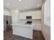 Well-lit kitchen features white cabinets, island, and stainless steel appliances at 10065 Quari Ct, Commerce City, CO 80022