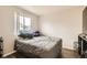 Bright bedroom featuring a window, wood-look floors, and a cozy bed at 1946 Ensenada St, Aurora, CO 80011