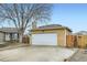 View of the home's two-car garage with a long driveway, plus a fenced in backyard at 1946 Ensenada St, Aurora, CO 80011