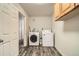 Functional laundry room featuring modern washer and dryer units and ample storage with wood-look flooring at 1946 Ensenada St, Aurora, CO 80011
