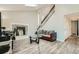 Living room featuring tall ceilings, a fireplace, wood-look floors, and an open staircase at 1946 Ensenada St, Aurora, CO 80011