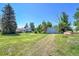 Exterior view of a lush backyard, a metal outbuilding, and a ranch-style home at 15065 Huron St, Broomfield, CO 80023