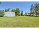 Sprawling green yard with mature trees, home, and large storage outbuilding at 15065 Huron St, Broomfield, CO 80023