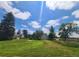 Expansive grassy yard with mature trees and open space under a bright, partly cloudy, blue sky at 15065 Huron St, Broomfield, CO 80023