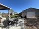 Inviting backyard patio area with outdoor dining set, fire pit, a lush lawn, and a shop building at 504 Elizabeth Ave, Platteville, CO 80651