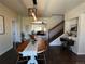 Open-concept dining area with a view of the living room, stairs, and abundant natural light at 504 Elizabeth Ave, Platteville, CO 80651