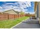 Well-maintained backyard with lush green grass, wood fence, concrete patio and space for outdoor enjoyment at 16076 Columbine Pl, Thornton, CO 80602